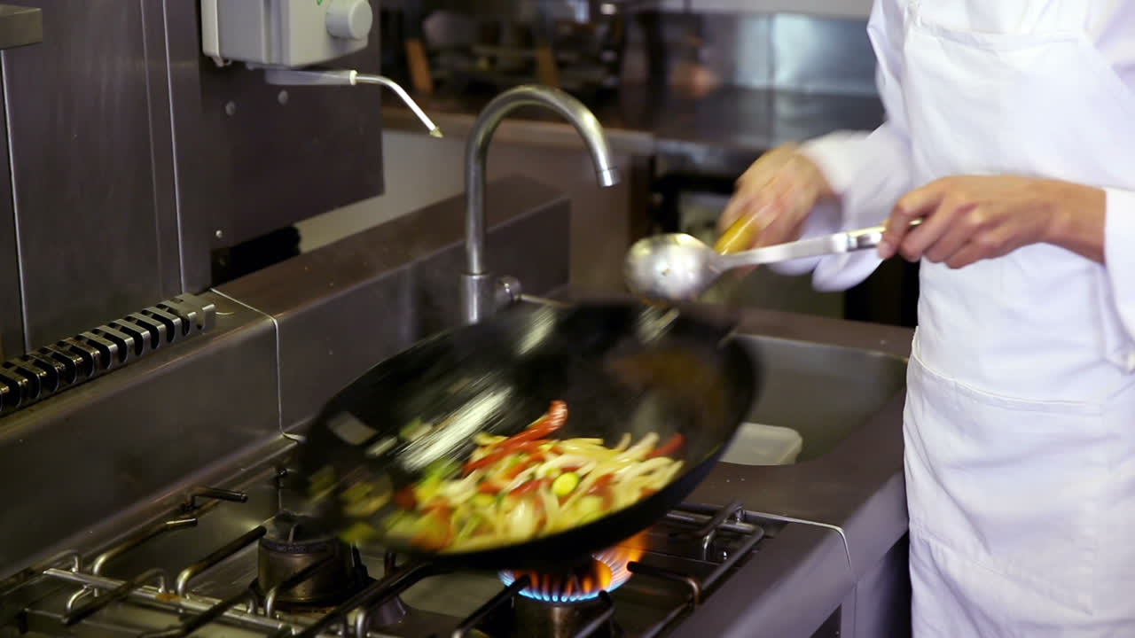 Chef che prepara un saltato in padella