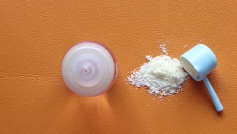 primer plano de leche en polvo para bebés y cuchara en el fondo de azulejos