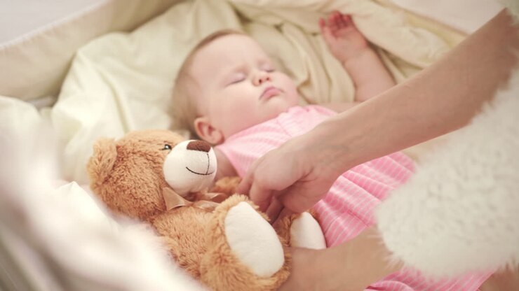 Beau bébé qui dort avec un ours en peluche
