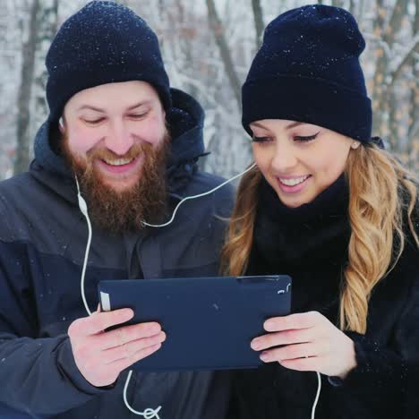 young couple walks in the park use a tablet