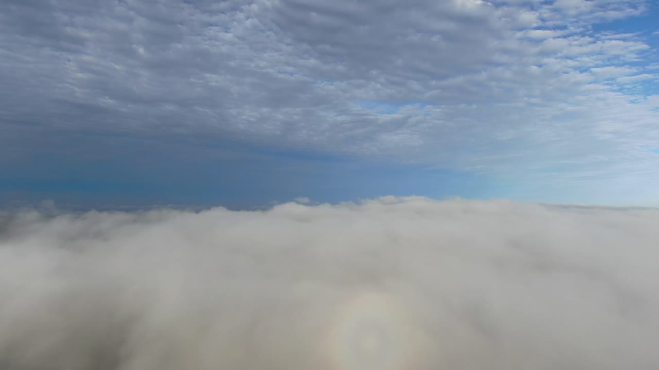 얼룩덜룩한 구름이 있는 아름다운 푸른 하늘날 안개 낀 풍경 위로 드론으로 공중 비행