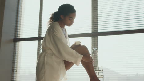 woman applying lotion in a luxurious bathroom