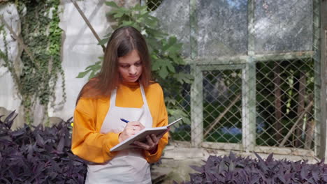 teenager taking notes in a greenhouse