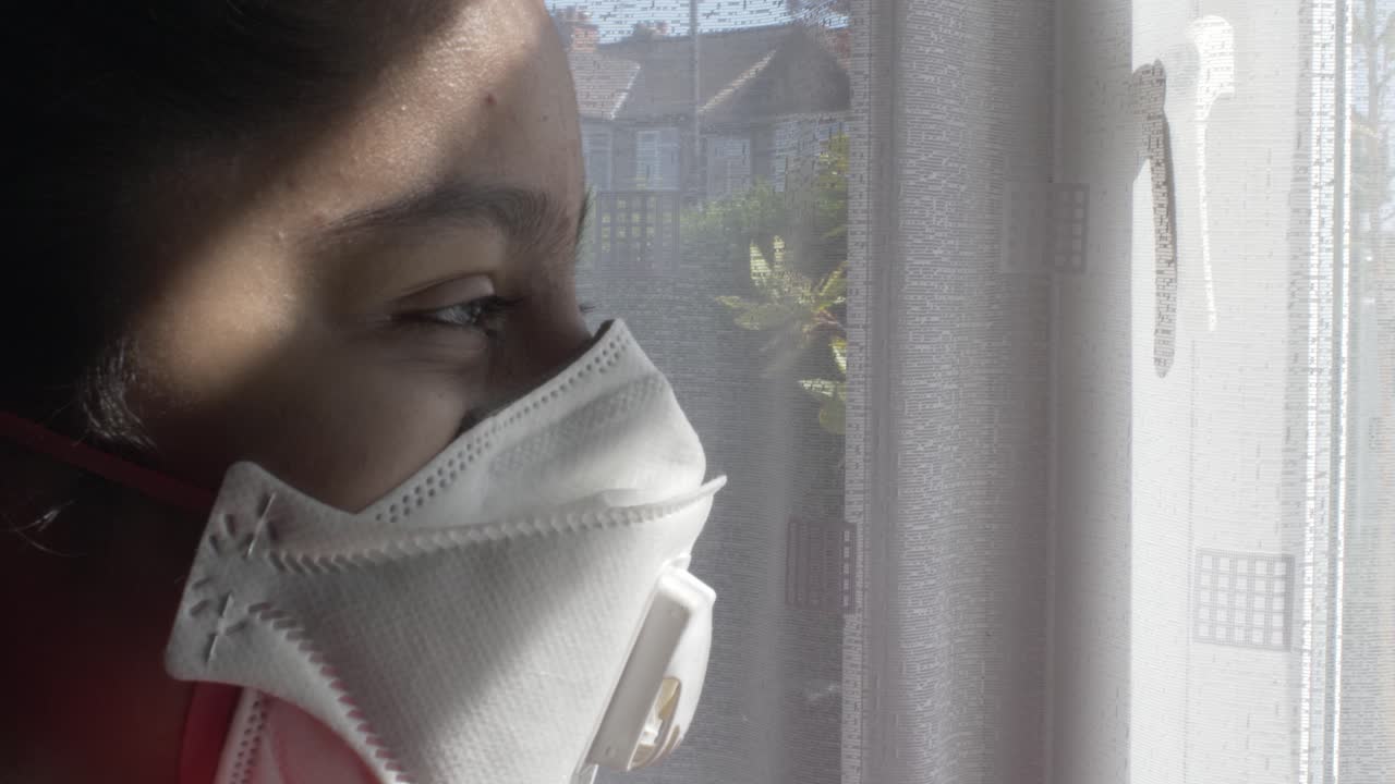 Asian Bangladeshi Child Wearing FFP Three Mask Indoors Looking Through Curtains