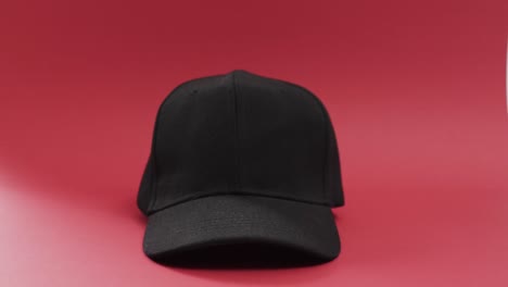 Video-of-black-baseball-cap-and-copy-space-on-red-background