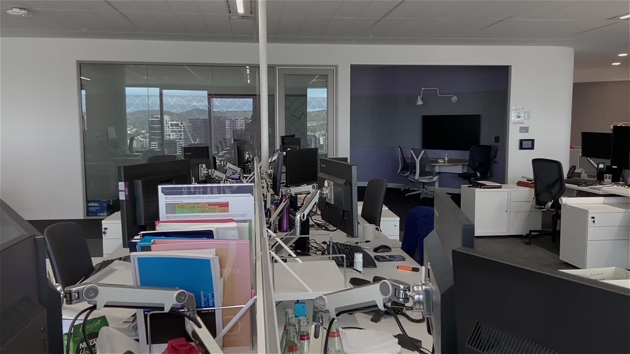 dolly de alta calidad disparó sobre escritorios vacíos en un edificio de oficinas grande y desierto con estaciones de trabajo desatendidas, durante el cierre pandémico del covid-19, con todos los empleados trabajando desde casa