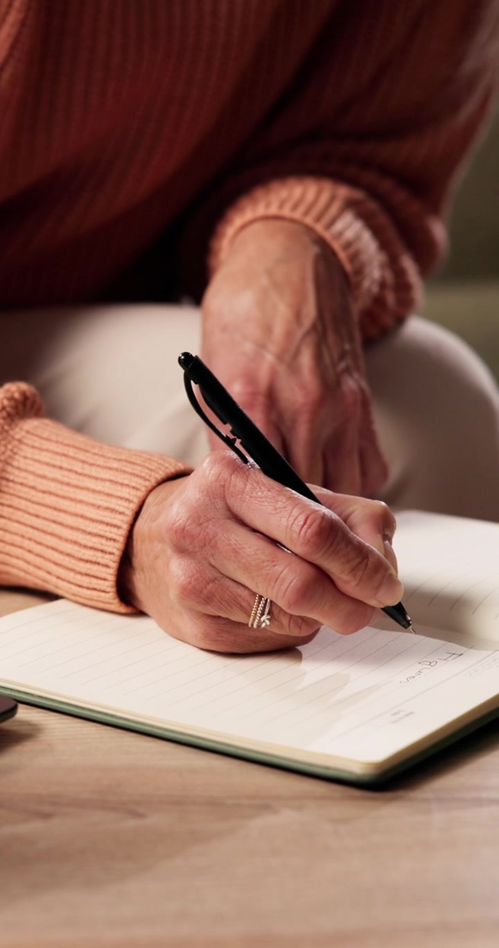 Primo piano di una donna che scrive su un taccuino