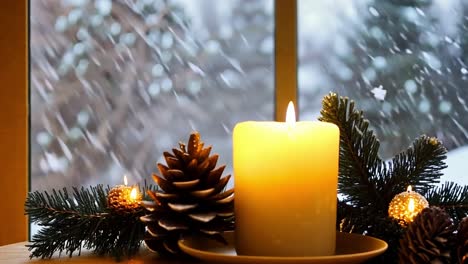 a cozy winter scene with a lit candle, pine cones, and evergreen branches