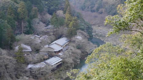 Japanisches-Dorf-An-Einem-Fluss-Am-Boden-Eines-Tals-In-Arashiyama,-Kyoto,-In-Japan