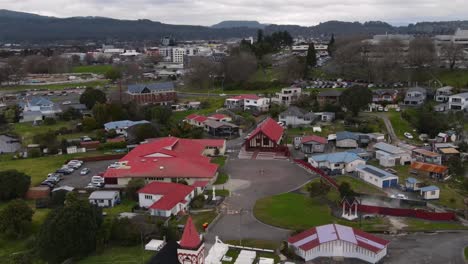 ohinemutu, rotorua - aerial pull back from te papaiouru marae and square reveal anglican church and war memorial on lakeshore