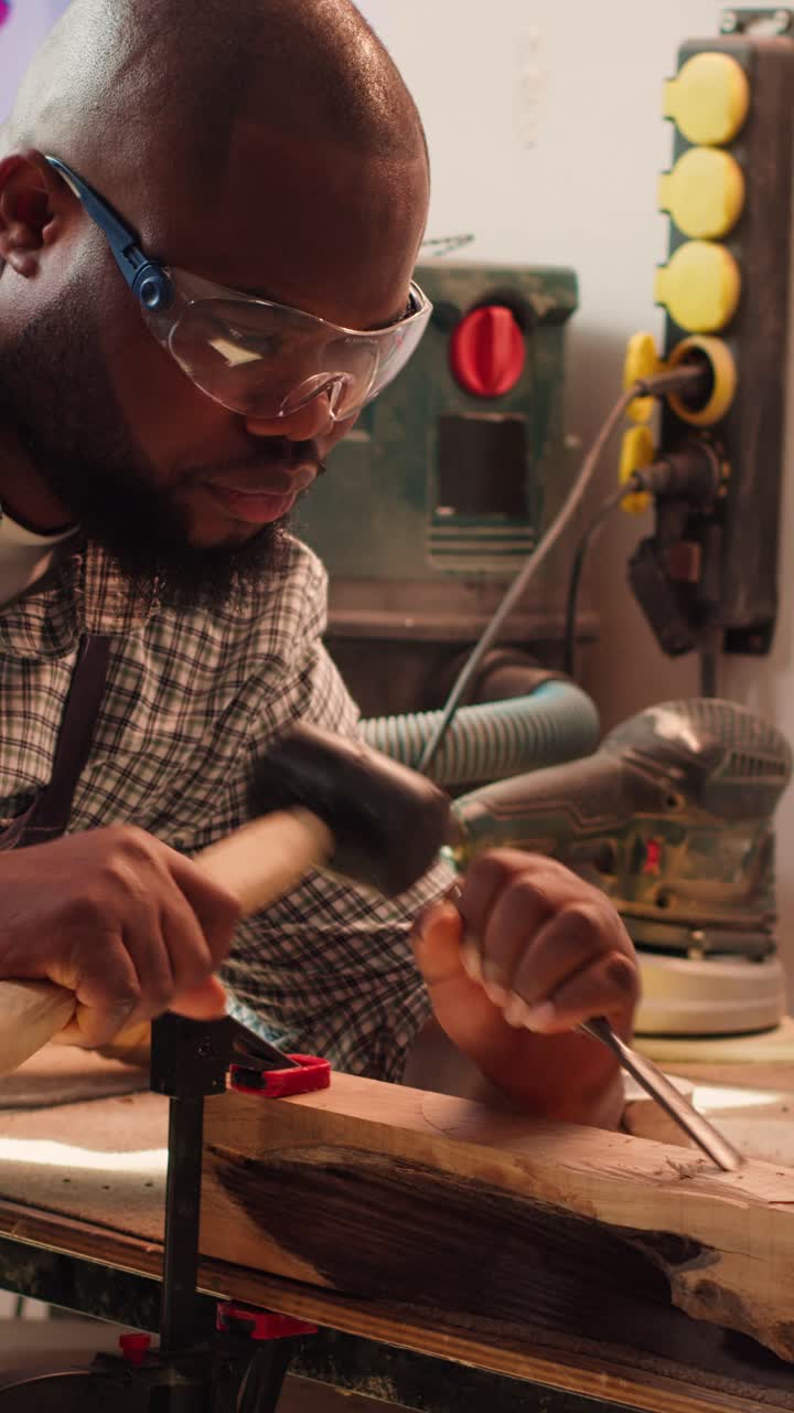 African American Man Carving Wood with Chisel and Mallet in Workshop