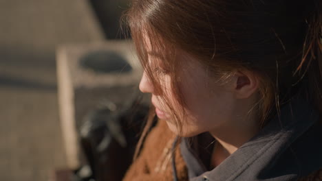 in a blurred background, a close-up of a disconsolate girl with her hair partially covering her face. her expression is one of deep sadness and introspection