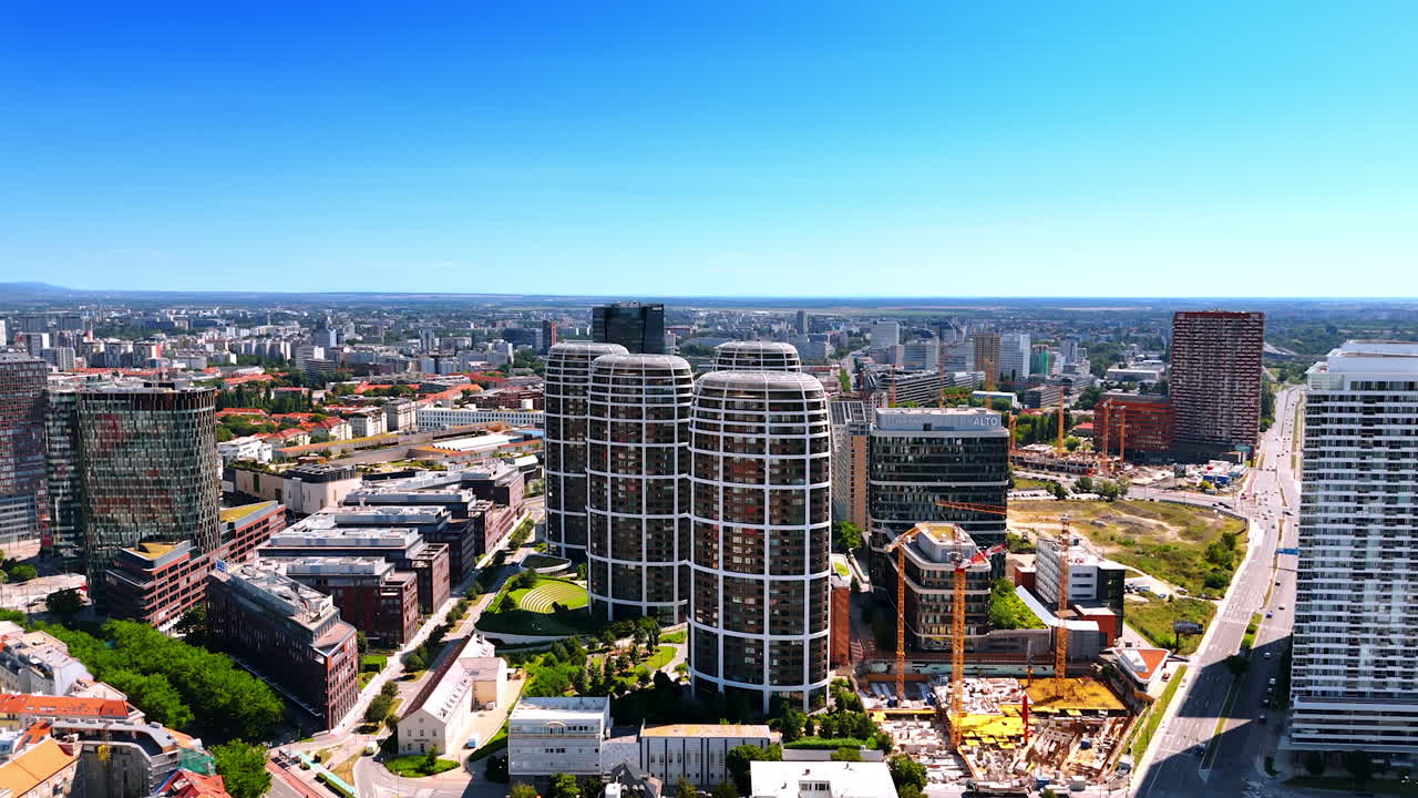 Approaching modern high-rising apartments in the New City Center. Traditional Bratislava buildings in the cityscape at backdrop. Aerial view