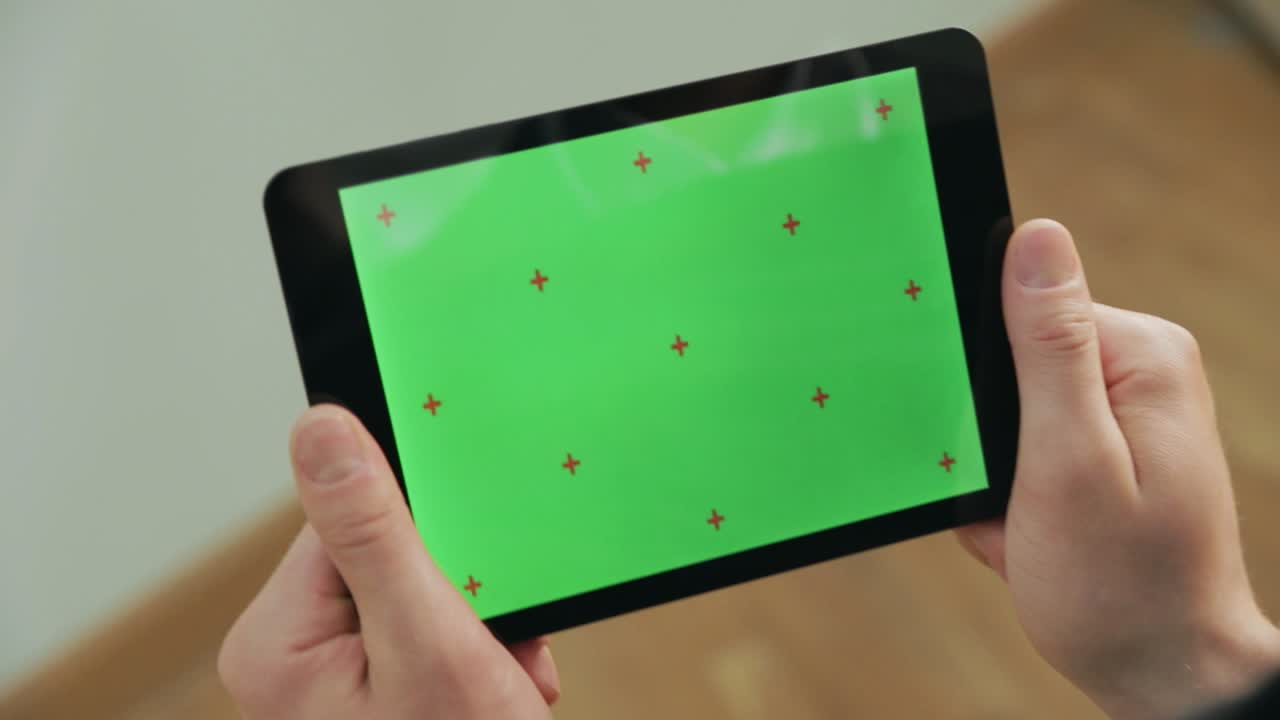 мужская рука касается планшета с зеленым экраном. зелёный экран планшета с цветной клавишей