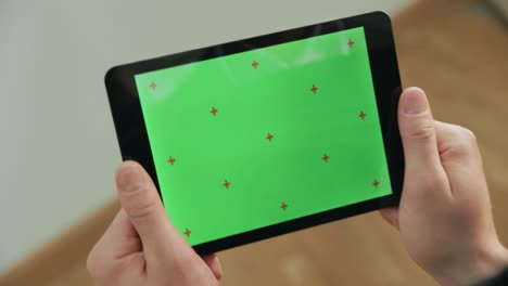 Männliche-Hand-Berührt-Green-Screen-Tablet.-Nahaufnahme-Des-Grünen-Chroma-Key-Tablet-Bildschirms