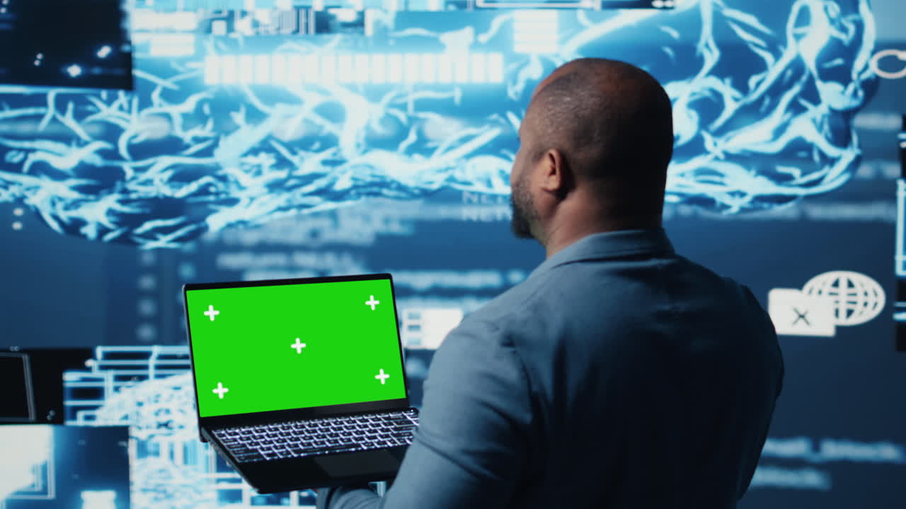 Black male engineer showing laptop with chroma key display