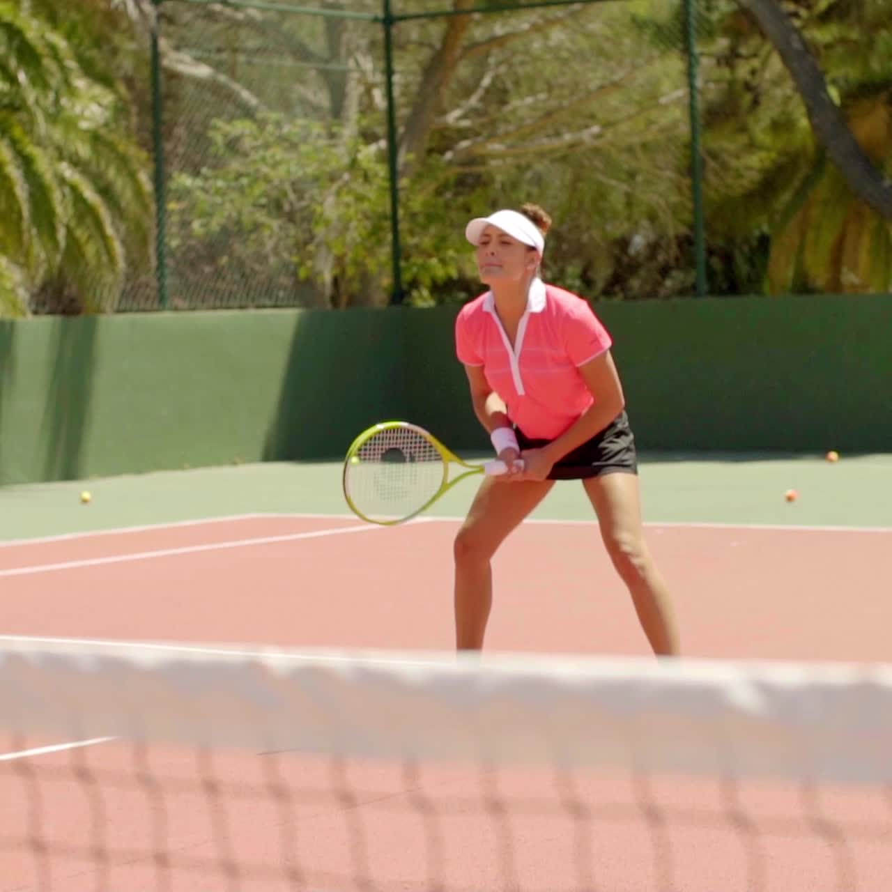 테니스 게임을 즐기는 매력적인 젊은 여성