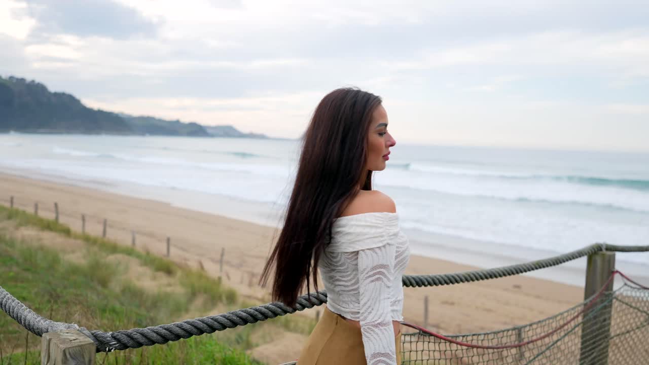 Woman on a bridge overlooking the ocean