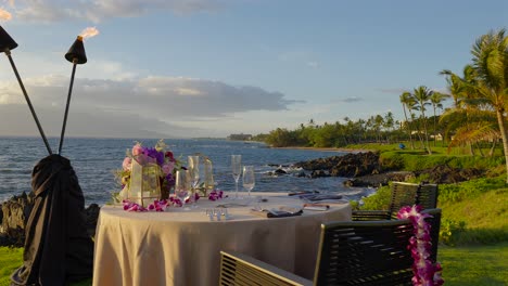 romantic table for two overlooking the sea and sunset, maui hawaii - pan left and slow motion