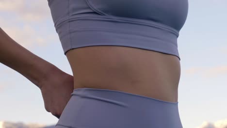 배 주위에 스포츠 레깅스를 조정하는 여자, 슬로우 모션 근접 촬영