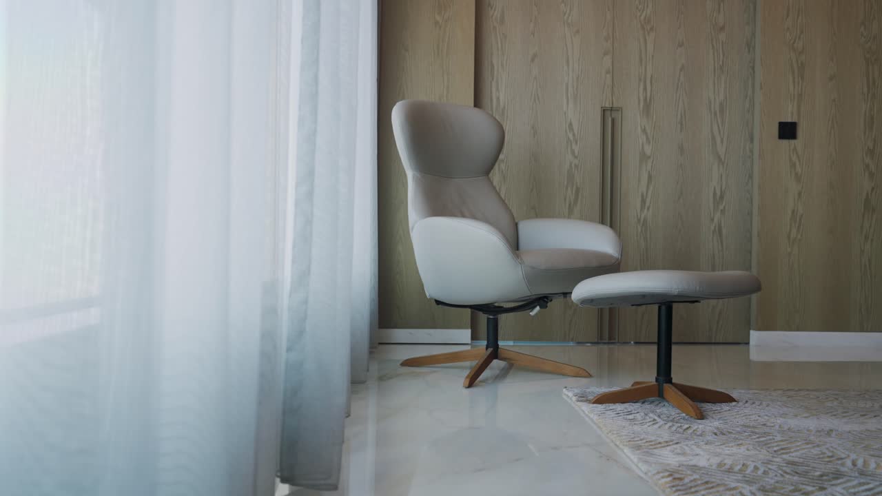 sillón blanco con taburete en la esquina de la habitación