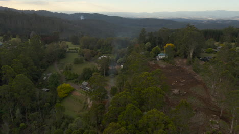 Static-aerial-view-of-fire-smoke-rising-from-homestead-and-regional-properties-below