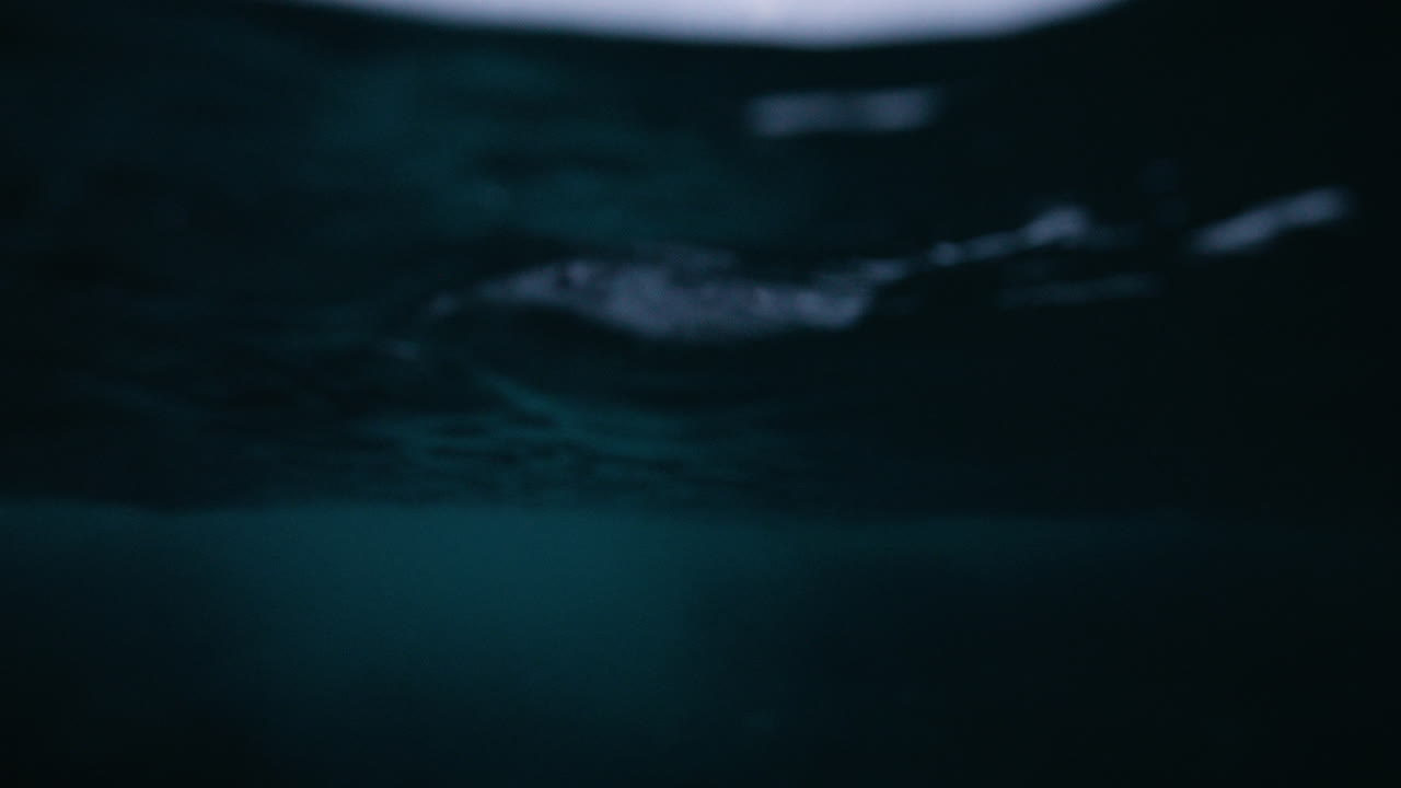 Half submerged Arctic Ocean with snowy Norway coastal mountains above waterline