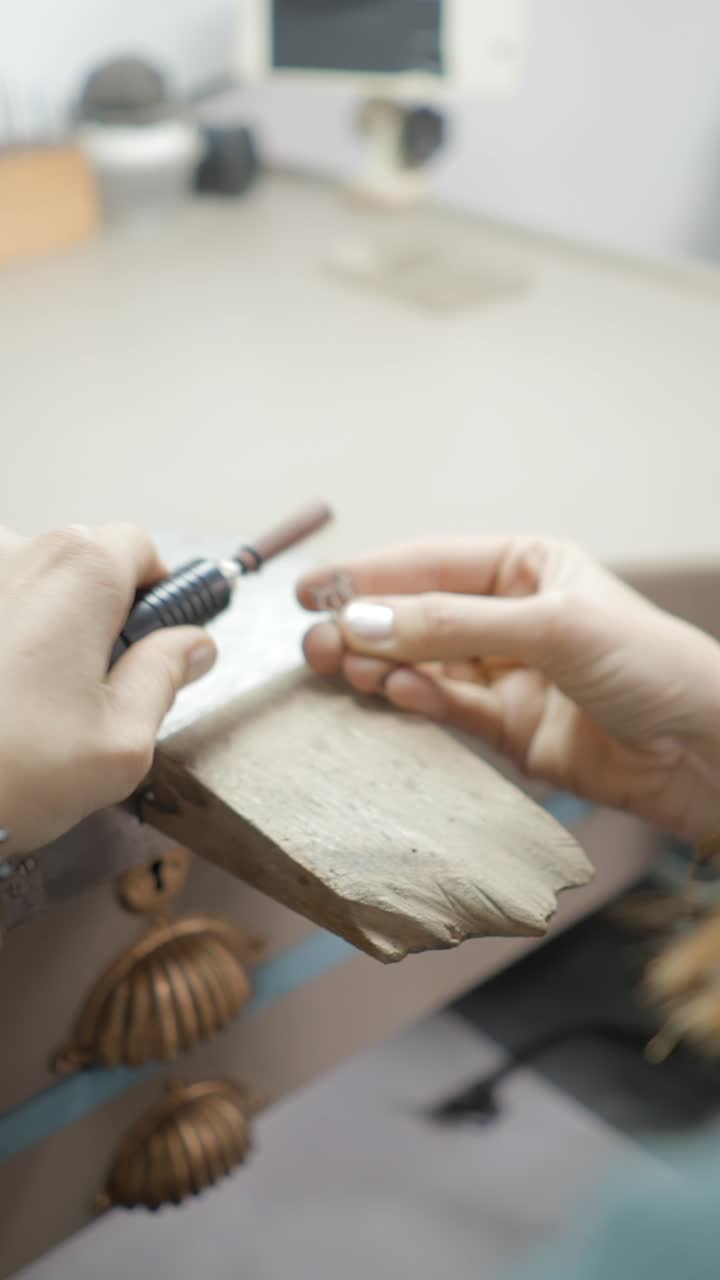 Primo piano di mani che creano gioielli con un utensile rotante