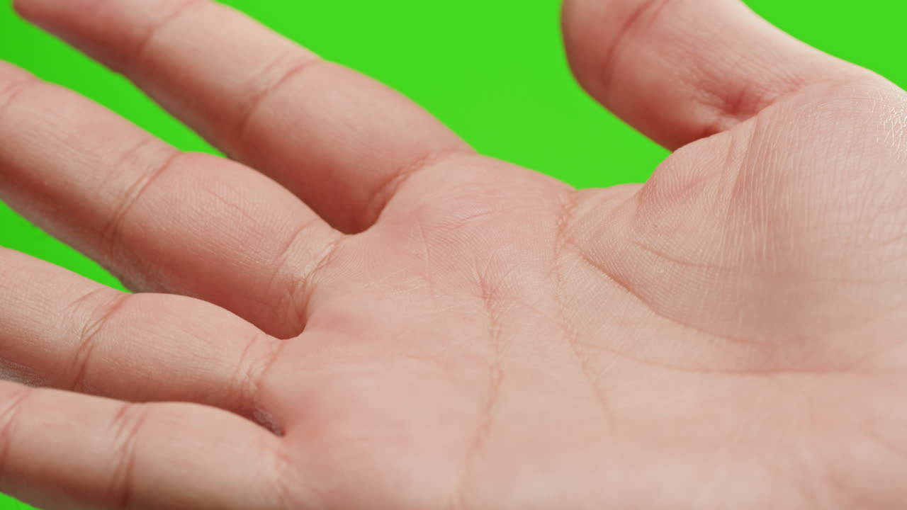 Close-up of a hand on a green screen