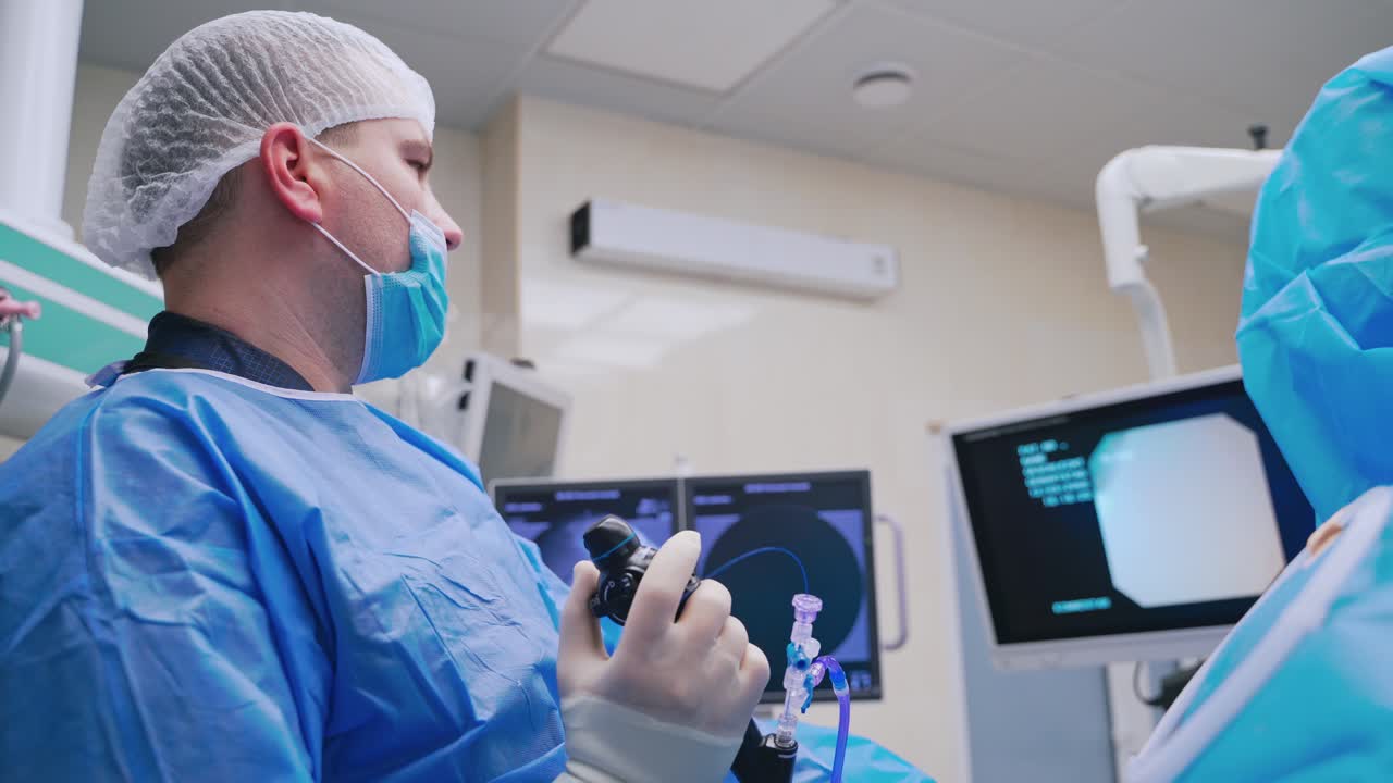 Laparoscopic surgery. Professional surgeon performing endoscopy surgery. Doctor looking on the monitor during the operation. New technologies in medicine.