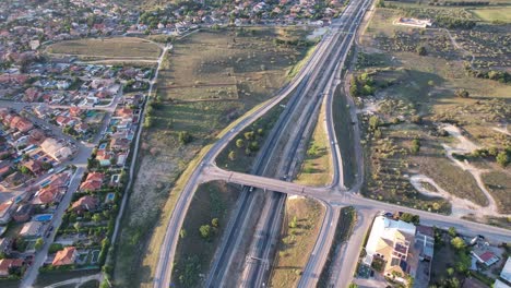 Vista-Aérea-Sobre-La-Salida-De-La-Autopista-Con-Algo-De-Tráfico-En-Un-Día-Soleado