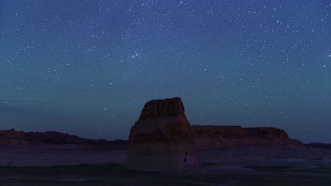 timelapse of stars, lone rock at lake powell, utah in foreground