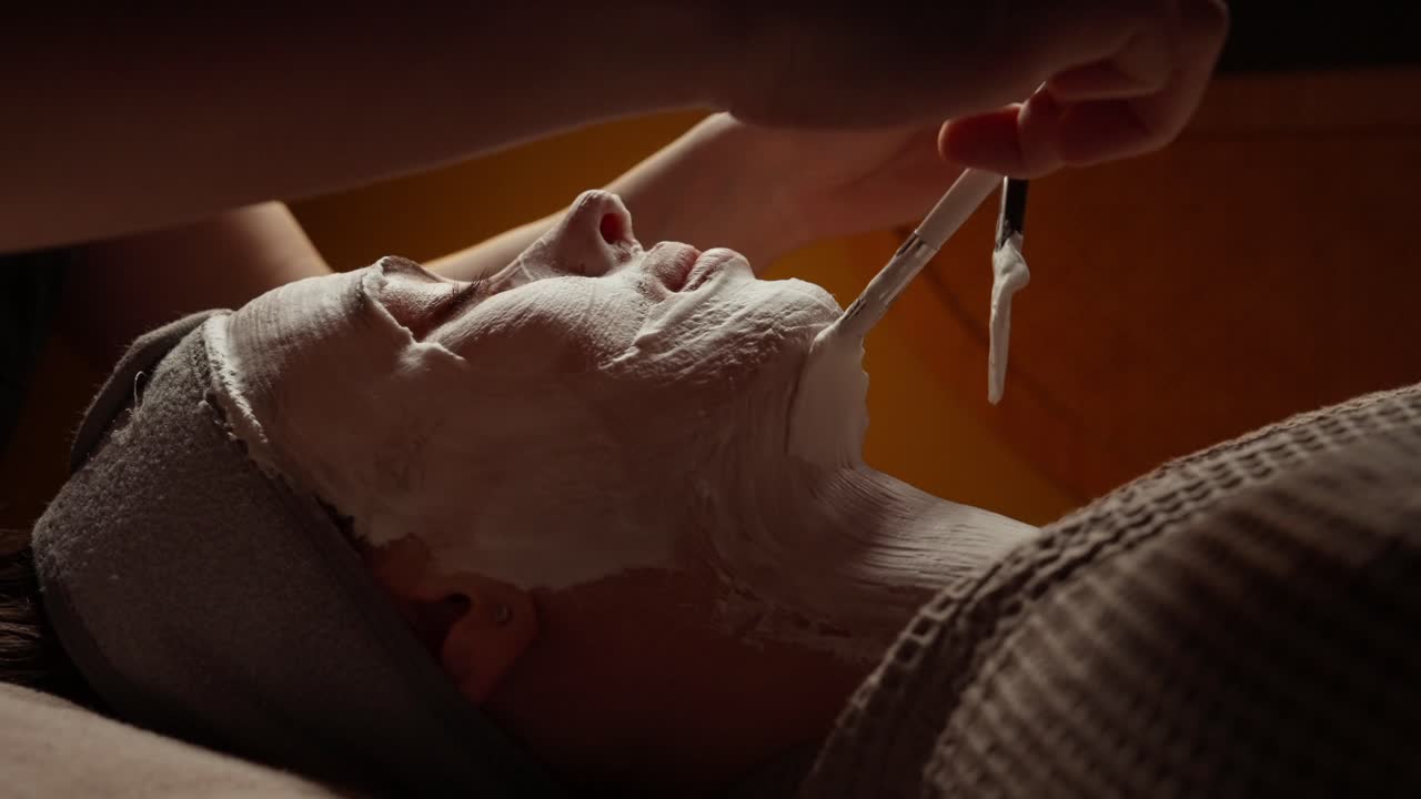 Nærbillede af kvinde, der får ansigtsmaskebehandling på et spa