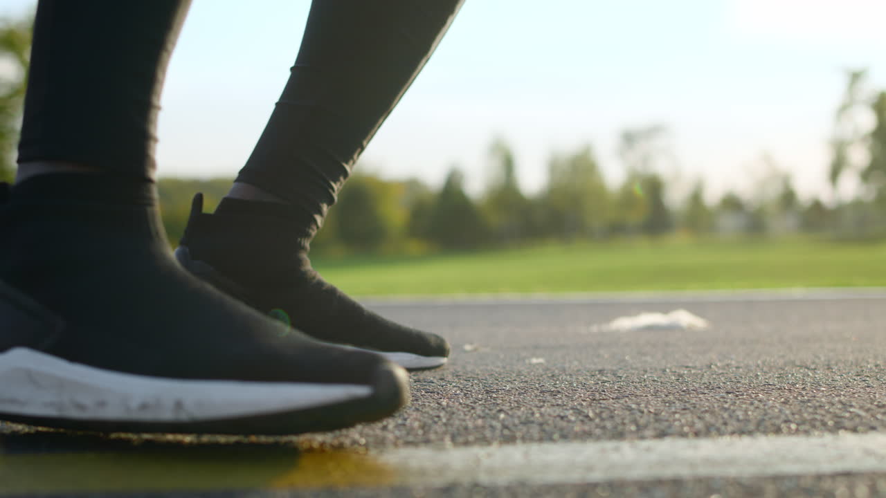 Man feet dancing on road. Active sportsman legs jumping in park.