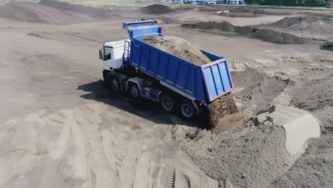 dump truck loading sand at construction site