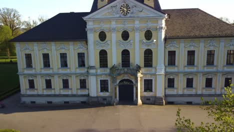 aerial drone ascend along yellow and white front of castle kravare with autumn foliage, historic architecture in czech republic