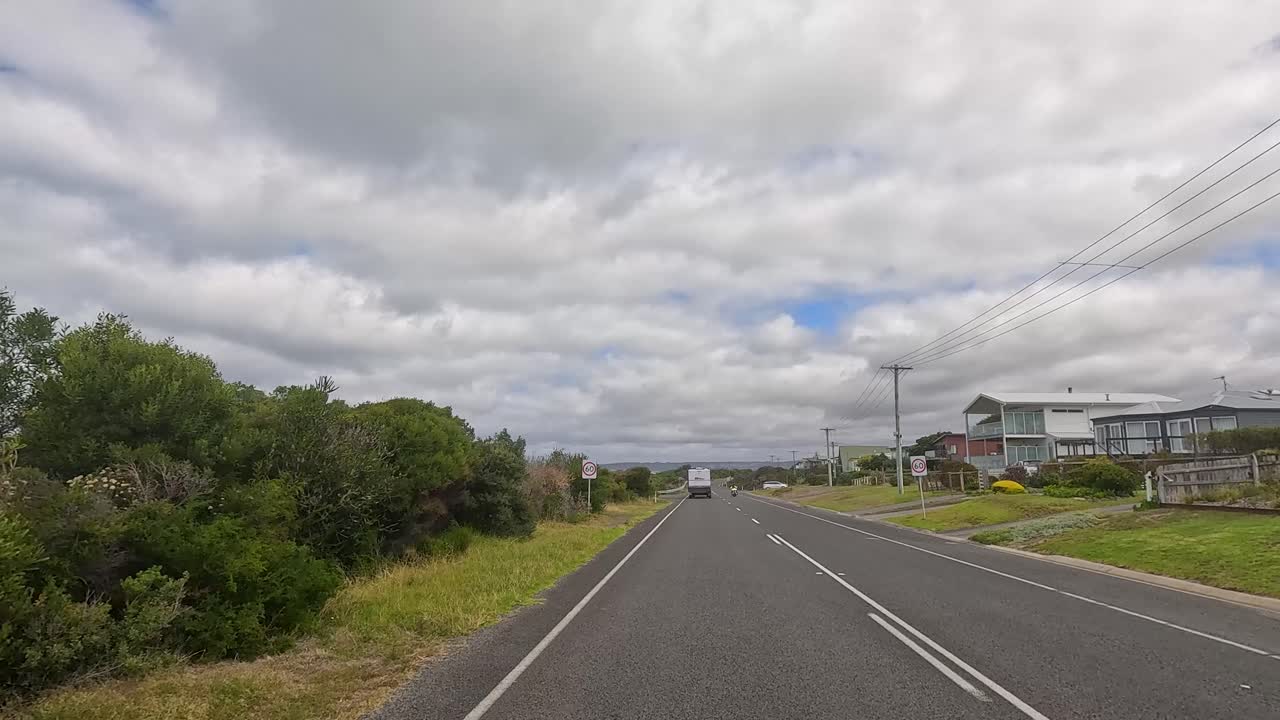 A 15-second video captures a drive along the Great Ocean Road, showcasing coastal views, greenery, and overcast skies