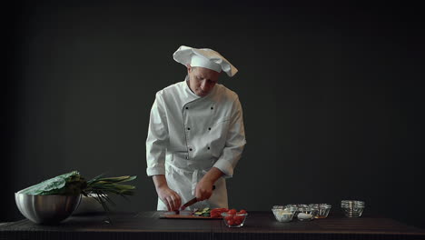 cocinero masculino cocinando y cortando verduras frescas. cocinero profesional trabajando en la cocina.