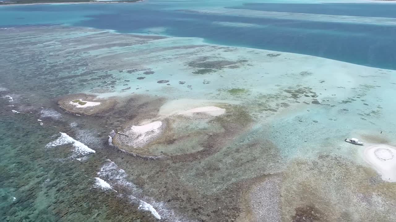 Moving-turn aerial view  beach cay  and-shallow-turquoise waters in the Caribbean sea in  SEBASTOPOL Los-roques National Park Venezuela.