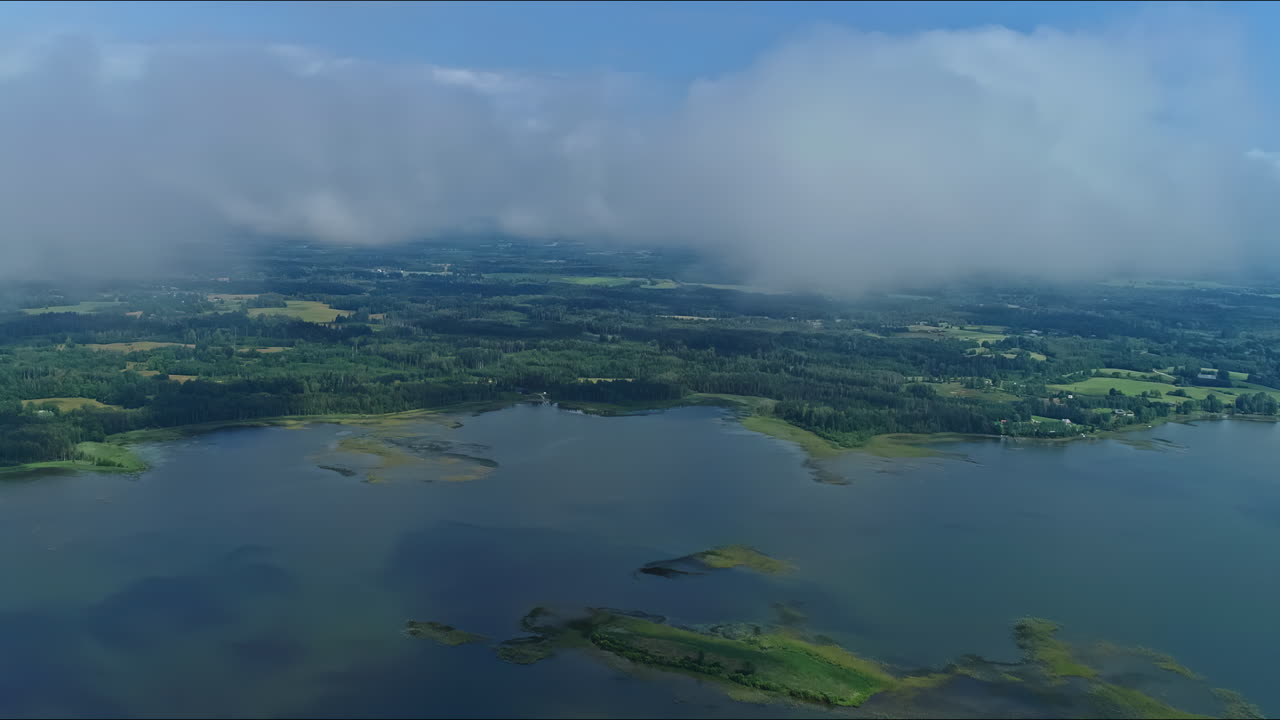 lapso de tiempo de nubes brumosas que envuelven una gran vía fluvial rodeada de un campo exuberante