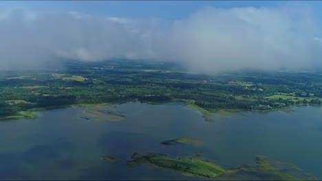time lapse of misty clouds shrouding a large waterway surrounded by lush countryside