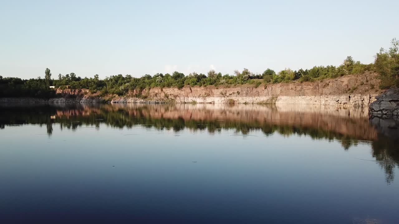 Aerial view of a beautiful lake at the site of a former quarry. Beautiful landscapes of wild nature with a lake with high banks of stone. 4k video.