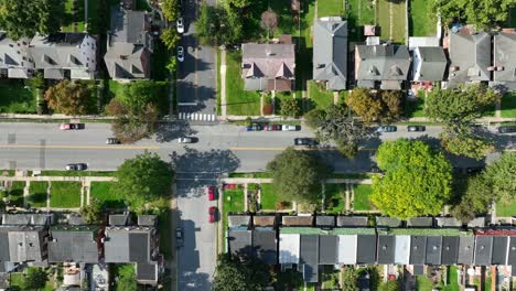 Residential-street-with-cars,-row-houses,-and-lush-trees