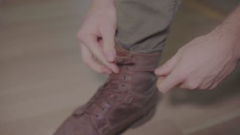persona atándose los cordones de los zapatos con las manos