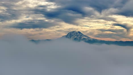 Mount-Rainier-Bei-Einem-Bewölkten-Sonnenuntergang-In-Washington,-USA,-Der-Sich-Langsam-Hinter-Nebelwolken-Versteckt