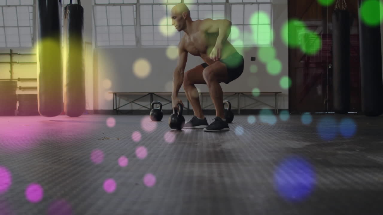 케틀벨을 들어 올리는 셔츠 벗은 남자가 다채로운 보케 조명 애니메이션을 통해 운동합니다.