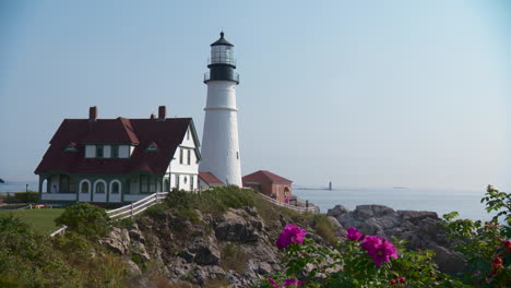 iconic maine lighthouse with flowers in the foreground