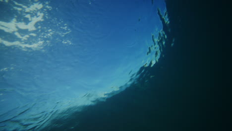 Geheimnisvoller,-Tiefblauer-Blick-Unter-Wasser-Auf-Den-Rücken-Einer-Brechenden,-Krachenden-Welle-Entlang-Der-Leine