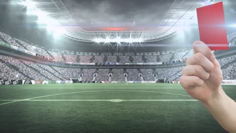Animation-of-hand-holding-red-card-over-stadium
