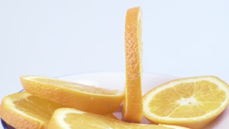 Close-up-fresh-valencia-orange-sliced-with-white-background-shallow-focus-and-slowly-rotating